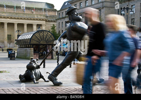 Flou de mouvement alors que les piétons marchent passé Dan désespérée dans le centre-ville de Dundee UK Banque D'Images