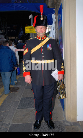 Edinburgh Fringe Festival Tattoo militaire , Scène de rue de cuivres Trompette trompettiste soldat en uniforme dans fur hat avec plumet rouge Banque D'Images