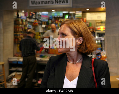 La navette businesswoman maintient occupé en attendant l'arrivée de son train Banque D'Images