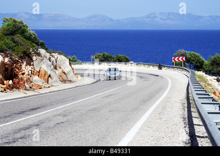 Voiture seul sur une route ensoleillée en mer littoral Banque D'Images