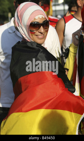 Une femme musulmane enveloppé dans le drapeau national allemand, Berlin, Allemagne Banque D'Images