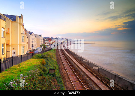 Lever du soleil à partir de la passerelle de fer dans le sud du Devon Dawlish à la recherche de la voie de chemin de fer vers la gare de Dawlish Banque D'Images