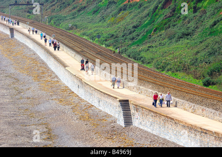 Les touristes à marcher le long de la promenade de front de mer à côté de la voie de chemin de fer entre Exmouth et dans le sud du Devon Dawlish Warren Banque D'Images