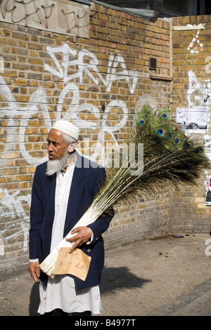 Man selling peacock feathers Brick Lane London England UK Banque D'Images