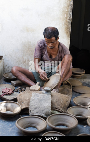 Village traditionnel d'argile moulage potter indien couvercles pour pots de faïence. Puttaparthi, Andhra Pradesh, Inde Banque D'Images