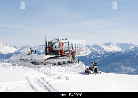 Snow cat labourant la neige pour construire un snowboard jump Banque D'Images