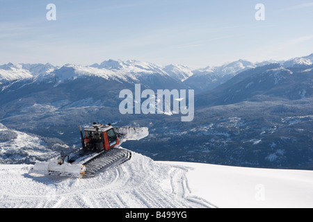 Snow cat labourant la neige pour construire un snowboard jump Banque D'Images