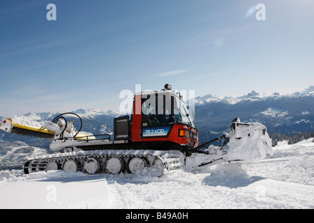 Snow cat labourant la neige pour construire un snowboard jump Banque D'Images