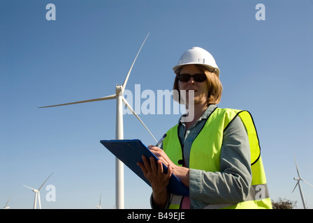 Ingénieur emplois de col vert femelle à côté de la turbine éolienne wind farm Banque D'Images