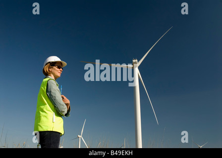 Ingénieur emplois de col vert femelle à côté de la turbine éolienne wind farm Banque D'Images