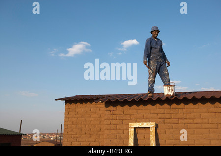 Peintre travaillant sur l'Afrique du Sud, Johannesburg RDP maison GreatStock Parution Modèle Collection Afrika Banque D'Images