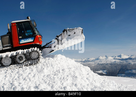 Snow cat labourant la neige pour construire un snowboard jump Banque D'Images