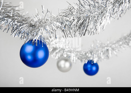 Bleu et argent baubles on silver tinsel Banque D'Images