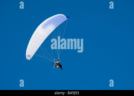 Un vol en parapente contre un ciel bleu clair Banque D'Images