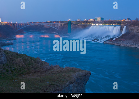 Les chutes américaines et le pont en arc-en-ciel au crépuscule, Niagara Falls, Ontario, Canada. Banque D'Images
