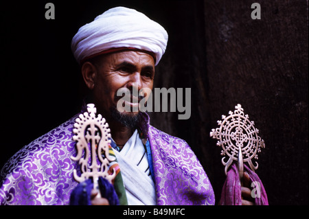 Un prêtre orthodoxe éthiopienne se tient près d'une des anciennes églises de Lalibela sculpté. L'Ethiopie Banque D'Images