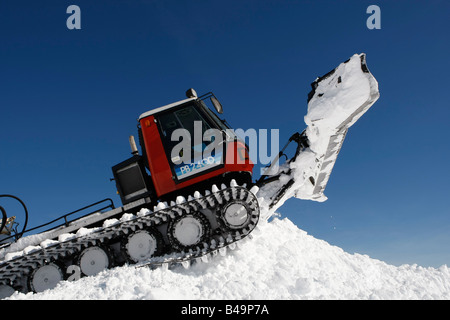 Snow cat labourant la neige pour construire un snowboard jump Banque D'Images