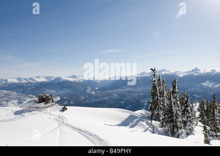 Snow cat labourant la neige pour construire un snowboard jump Banque D'Images