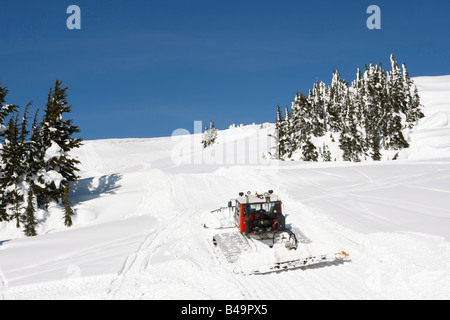 Snow cat labourant la neige pour construire un snowboard jump Banque D'Images