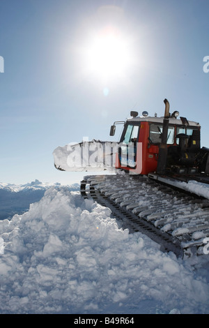 Snow cat labourant la neige pour construire un snowboard jump Banque D'Images