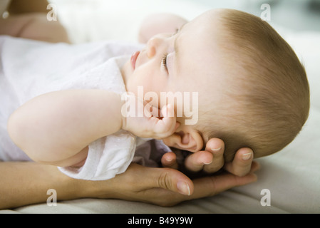 Bébé couché sur mother's hands, portrait Banque D'Images