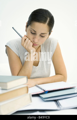 Jeune femme assise avec pile de livres, l'étude de notebook Banque D'Images