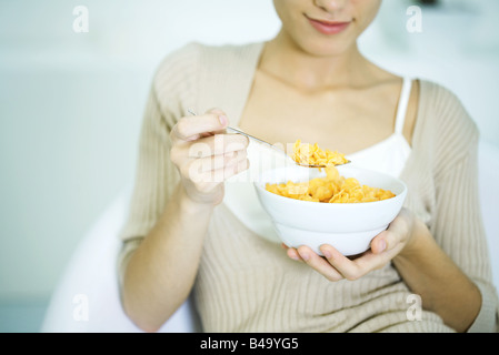 Woman holding bowl of cereal, cropped view Banque D'Images