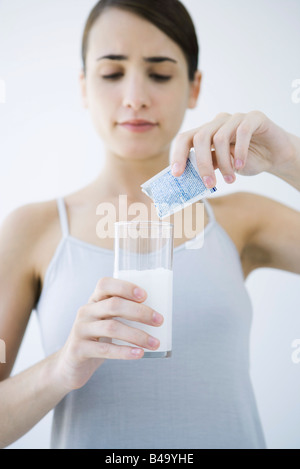 Woman pouring médecine effervescent dans un verre d'eau Banque D'Images