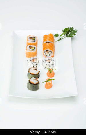 Assortiment de maki sushi disposés sur la plaque sushi Banque D'Images