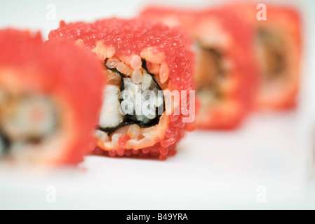 Portrait de maki sushi roulé en oeufs de poisson volant rouge, close-up Banque D'Images