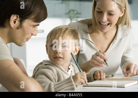 Coloriage petit garçon à table avec les parents, à la recherche de père Banque D'Images