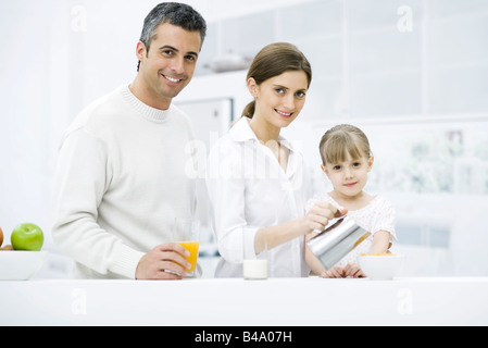 Famille préparer le petit-déjeuner dans la cuisine, smiling at camera Banque D'Images