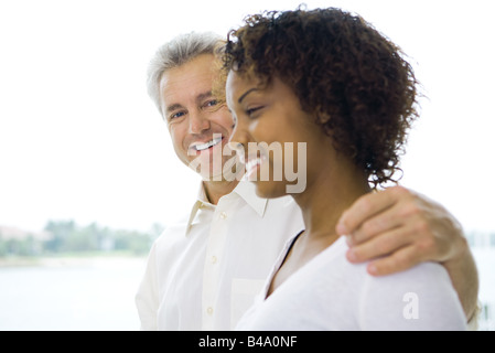 Homme mature avec bras autour de l'épaule de la jeune femme, à la fois smiling Banque D'Images