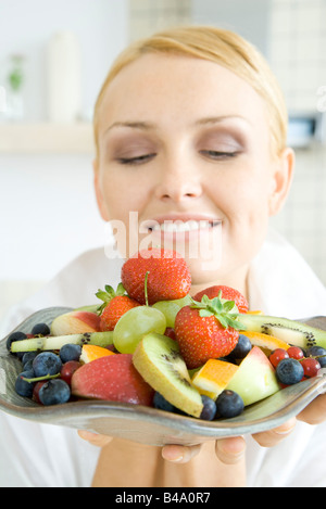 Woman holding plateau de fruits, salade, close-up Banque D'Images