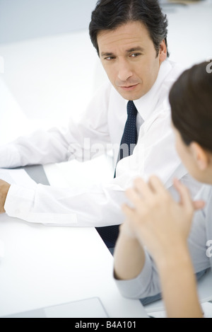 Professional man sitting at desk, parler avec les collègue, high angle view Banque D'Images