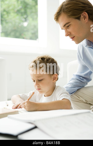 Père Fils d'aider les jeunes à faire leurs devoirs Banque D'Images