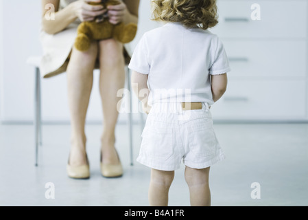 Enfant timide face woman holding stuffed toy, cropped view Banque D'Images