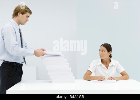 L'ajout de l'homme à grande pile de documents sur la femme professionnelle 24 Banque D'Images