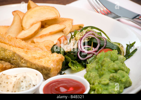 La morue légèrement les quartiers de pommes de terre battue avec des trempettes et Petits Pois Banque D'Images