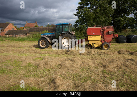 Ford Tracteur avec presse à balles rondes UK Banque D'Images