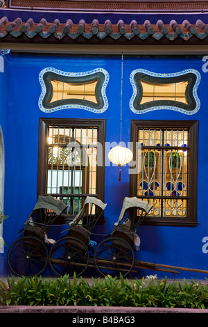 Asie, Malaisie, Penang, Pulau Pinang, Georgetown, quartier chinois, détail de Trishaws alignés contre un mur peint en bleu Banque D'Images