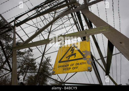 Un signe montrant une mort instantanée met en garde contre toute personne escalade ce pylône de l'électricité Comité permanent dans les bois près de Wrington, North Somerset Banque D'Images