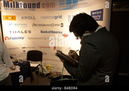 La prise de notes sur un stand lors d'un graduate expo fair où les recruteurs d'entreprise de rencontrer les jeunes de commencer à travailler Banque D'Images