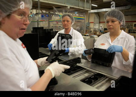 Les femmes des moments finis paquet de biscuits à l'United Biscuits Delacre appartenant à l'usine de production de Lambermont Banque D'Images