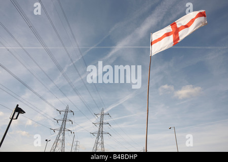 Une croix de saint Georges les volets du pavillon dans une forte brise sur un mât près de pylônes en Grays, Thames Gateway Banque D'Images