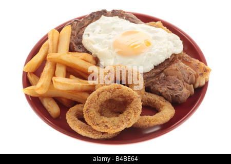 Faux Filet de boeuf frais Steak AVEC UN Œuf frit, des oignons et des frites contre un fond blanc isolé avec aucun peuple et un chemin de détourage Banque D'Images