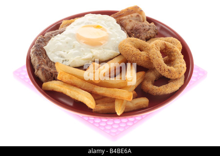 Faux Filet de boeuf frais Steak AVEC UN Œuf frit, des oignons et des frites contre un fond blanc isolé avec aucun peuple et un chemin de détourage Banque D'Images