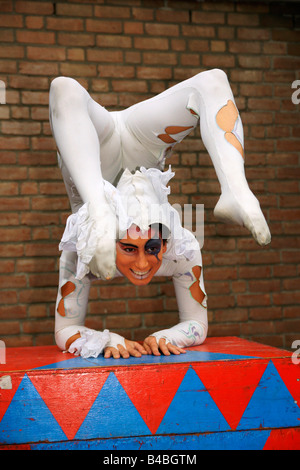 Jeune femme italienne souple clown contorsionniste montrent l'exécution de l'ensemble du corps tordues sourire face à l'un envers l'extérieur circus Banque D'Images