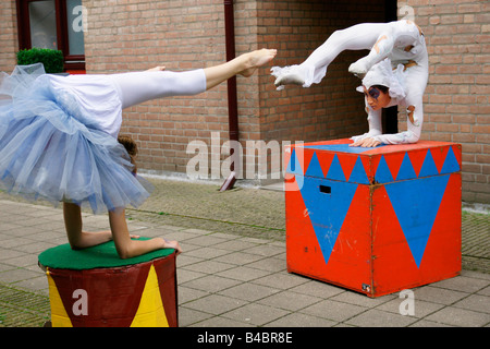 Les jeunes femmes italiennes souple clown contorsionniste montrent l'exécution de l'ensemble du corps tordu sourire face à deux à l'envers l'extérieur circus Banque D'Images