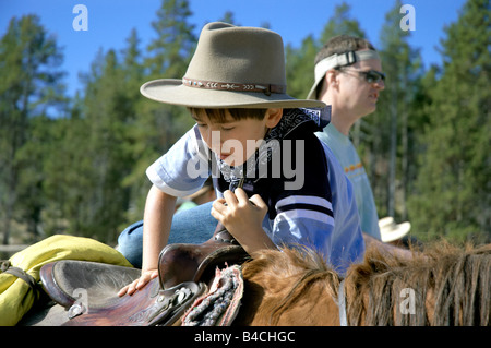 Jeune garçon du montage d'un grand cheval sur un ranch en Amérique du Nord Banque D'Images